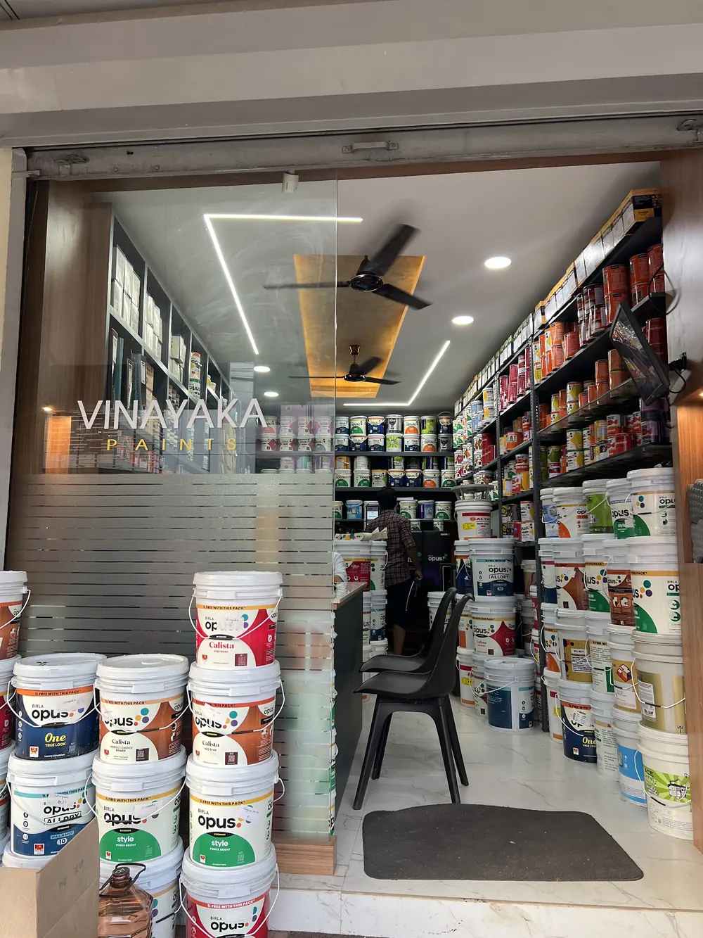 Well-stocked aisle of paint buckets at Vinayaka Paints